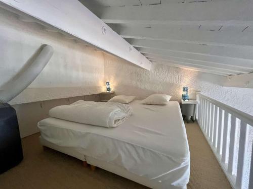 - un lit blanc dans une chambre avec un escalier dans l'établissement Studio/Mezzanine aux Marines de Cogolin - FR-1-226B-238, à Cogolin
