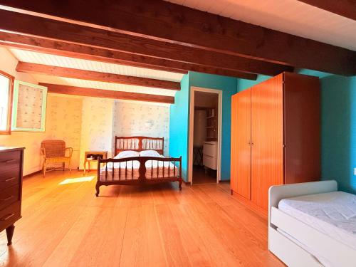 - une chambre avec un lit, des murs bleus et du parquet dans l'établissement La Quiétude Oléronaise - Plage à 1.5km - 8 personnes - FR-1-778-49, à Dolus-d'Oléron