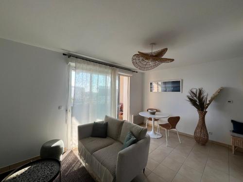 un salon avec un canapé et une table dans l'établissement T2 lumineux en centre-ville avec balcon et parking sécurisé - FR-1-319-612, à La Teste-de-Buch
