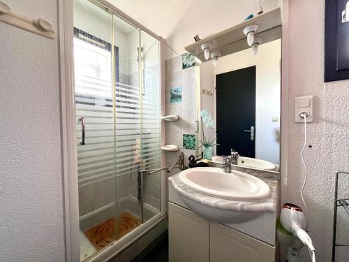 une salle de bain avec un lavabo et une douche en verre dans l'établissement Maison familiale climatisée avec terrasse près de la plage, Saint-Cyprien - FR-1-309-510, à Saint-Cyprien
