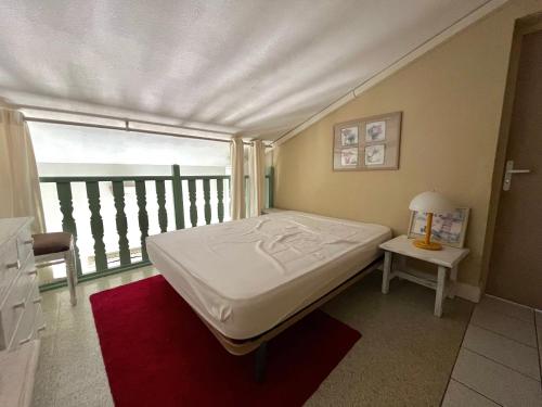 un lit dans une chambre avec une grande fenêtre dans l'établissement Maison familiale climatisée avec terrasse près de la plage, Saint-Cyprien - FR-1-309-510, à Saint-Cyprien