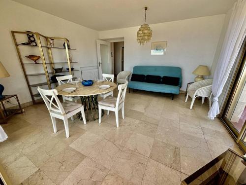 un salon avec une table, des chaises et un canapé dans l'établissement Appartement spacieux - Vue mer - Proche plage - FR-1-816-30, au Lavandou