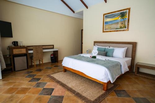 a bedroom with a bed and a desk and a television at Vida Homes Sipalay in Sipalay