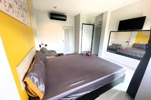 a bedroom with a bed and a large mirror at Baan Pak Sud Soi in Ban Rai
