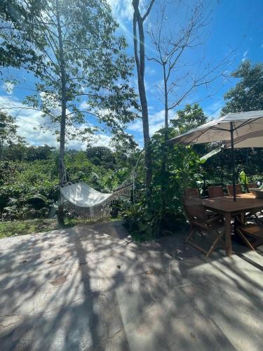 a picnic table with an umbrella and a hammock at Amazon Paradise WiFi Starlink Work or Relax in Morales