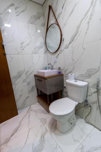 a white bathroom with a toilet and a sink at Hostel Village GRU in Guarulhos