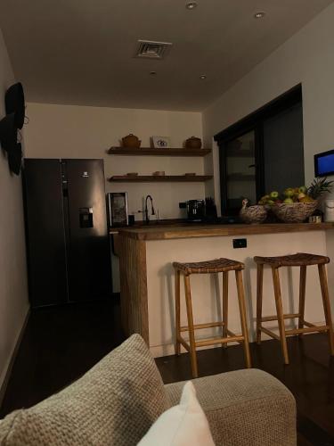 a kitchen with a counter and a refrigerator and two stools at Amazon Paradise WiFi Starlink Work or Relax in Morales