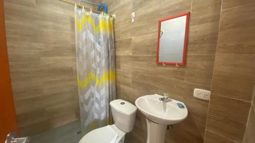 a bathroom with a toilet and a sink and a mirror at Amazonas magic in Leticia