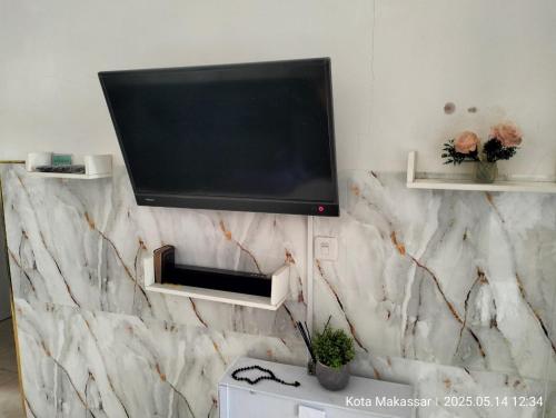 Televisyen dan/atau pusat hiburan di Guest House Makassar Beach