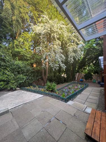 a garden with a lot of flowers and a bench at Sasha-Home 538 Brookmere Ave in Coquitlam