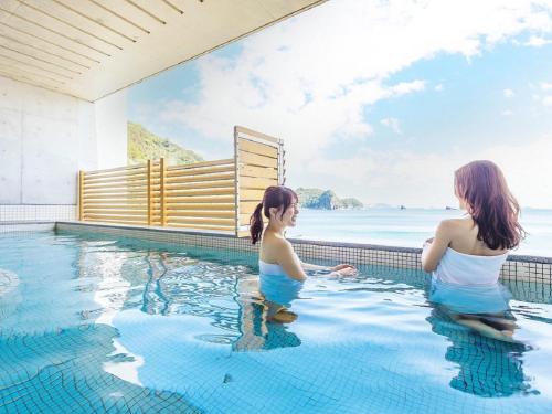 two women in the swimming pool at a resort at Nichinankaigan Nango Prince Hotel in Nichinan