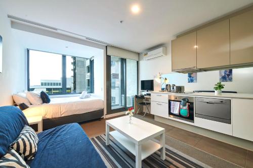 un soggiorno con un letto e un tavolo di Sky-High Serenity with Stunning Views on Level 32 a Melbourne