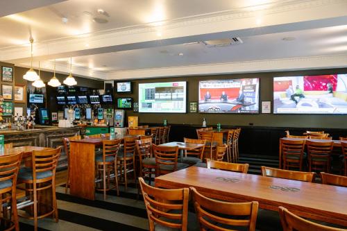 a restaurant with tables and chairs and televisions at Hotel Concord in Sydney