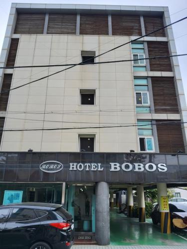 a building with a hotel lobos sign in front of it at BOBOS Hotel in Jeju