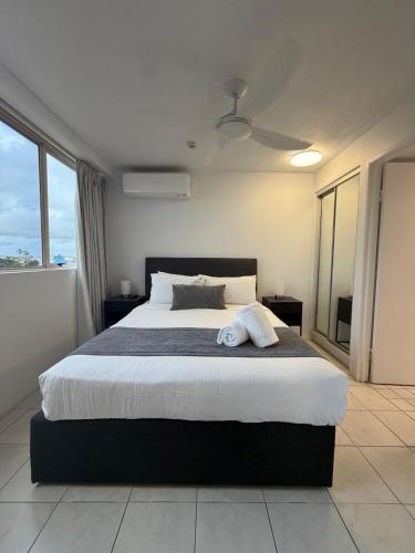 a bedroom with a large bed and a large window at Point View at The Sandcastles Resort Mooloolaba in Mooloolaba