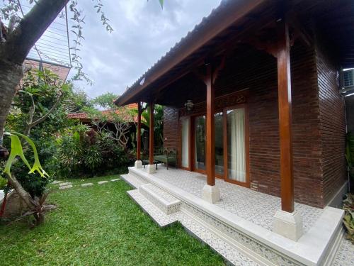a building with a walkway next to a yard at Tiis Garden Puri Villas in Gianyar