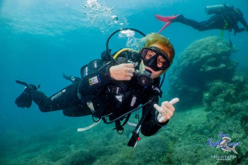 a man with a camera is diving in the water at Vida Homes Sipalay in Sipalay