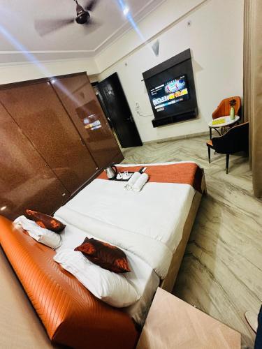 a hotel room with a bed and a tv at JPM Suites Noida 70 in Noida