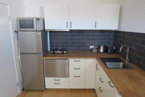 a kitchen with a white refrigerator and a sink at St Caths Anchorage in Brisbane