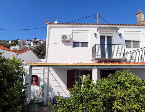a white house with a balcony at Angelina's House in Glossa