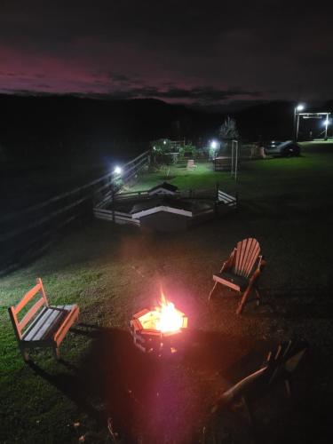 two chairs sitting around a fire in a yard at night at Paraiso do Campestre in Urubici
