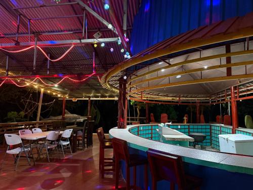 a restaurant with a pool and tables and chairs at Hospedaje Estrella Del Golf, Playa, Puerto Jimenez in Puerto Jiménez