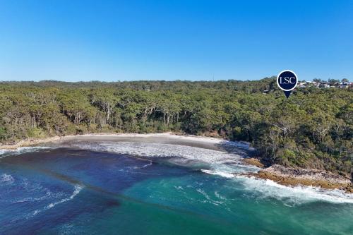 an air balloon flying over a beach next to the ocean at Studio By The Bay in Vincentia