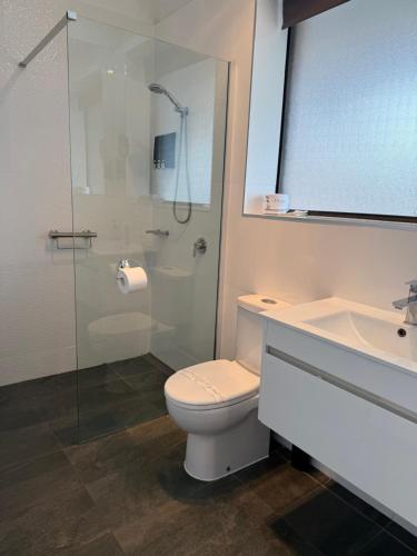 a bathroom with a toilet and a sink and a shower at Tropicana Motor Inn in Cowes
