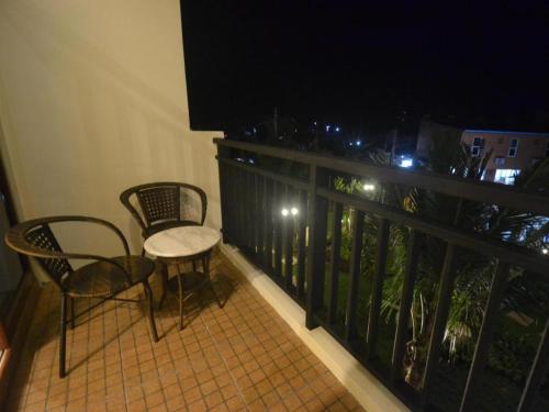 a balcony with a table and chairs and a television at The Green Hotel in Ko Lipe