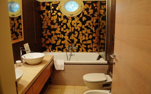 a bathroom with a toilet and a sink and a tub at Tenuta Monacelle in Selva di Fasano