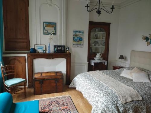 une chambre avec un lit et une chaise dans l'établissement Appartement Cosy avec jardinet, à Dieppe