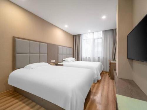 a hotel room with two beds and a flat screen tv at Jitai Hotel Shanghai Yangpu Benxi Hospital Branch in Shanghai