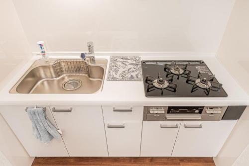 a kitchen with a sink and a stove at 華夏民宿 in Tokyo