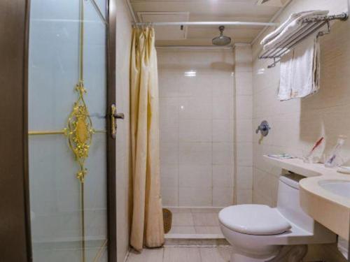a bathroom with a shower and a toilet and a sink at Kunlun Leju Business Hotel Kaifeng Gulou in Kaifeng