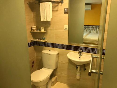 a bathroom with a toilet and a sink at Happy Family Hotel in Macau