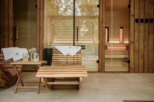 a wooden chair sitting next to a table on a patio at Pinia Slnava 01 - Luxury lakeside apartment with pool in Banka
