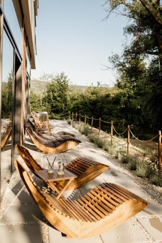 a group of wooden tables and chairs on a patio at Pinia Slnava 01 - Luxury lakeside apartment with pool in Banka