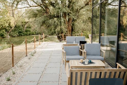 a patio with chairs and tables next to a building at Pinia Slnava 01 - Luxury lakeside apartment with pool in Banka