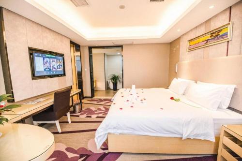 a hotel room with a bed and a flat screen tv at Lavande Hotel Yichang Railway East Station Branch in Yichang