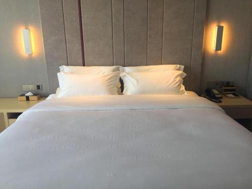 a large white bed in a hotel room at Lavande Hotel Yichang Railway East Station Branch in Yichang