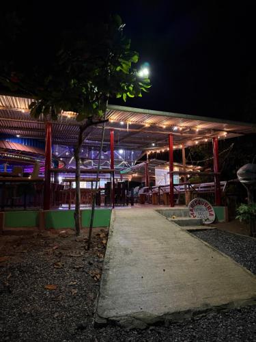 a night view of a building with a table at Hospedaje Estrella Del Golf, Playa, Puerto Jimenez in Puerto Jiménez