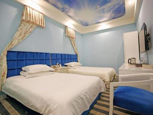 two beds in a room with a blue wall at TO915101 STILL LOVE THEME HOTEL in Chengdu