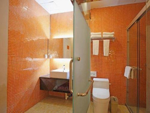 a bathroom with a toilet and a sink with orange tiles at TO915101 STILL LOVE THEME HOTEL in Chengdu