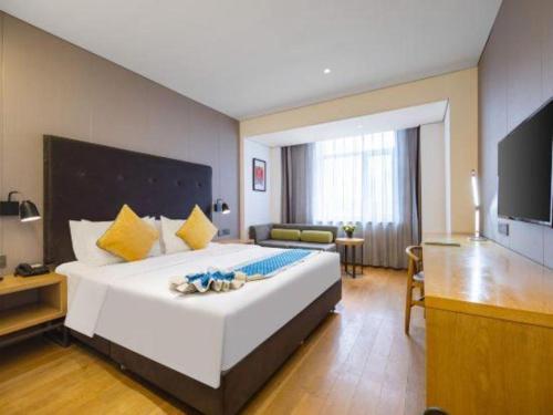 a hotel room with a large bed and a television at Yitel Shenyang Sanhao Street Shengjing Hospital in Shenyang