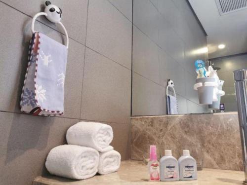 a bathroom with towels and a mirror and a sink at Yitel Shenyang Sanhao Street Shengjing Hospital in Shenyang