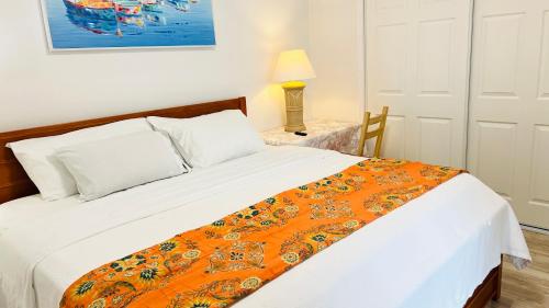 ein Schlafzimmer mit einem Bett mit einer orangefarbenen Decke in der Unterkunft Amazing Waterfront Apt near Disney and Lake Tohoa in Kissimmee