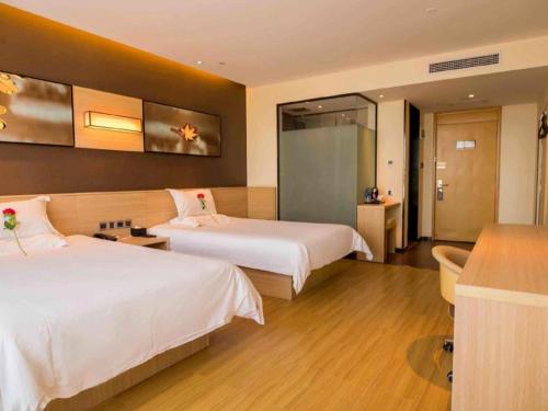 a hotel room with two beds and a bathroom at IU Hotel Zhangye High-Speed Railway Station in Zhangye