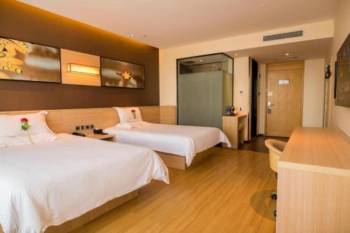 a hotel room with two beds and a bathroom at IU Hotel Zhangye High-Speed Railway Station in Zhangye
