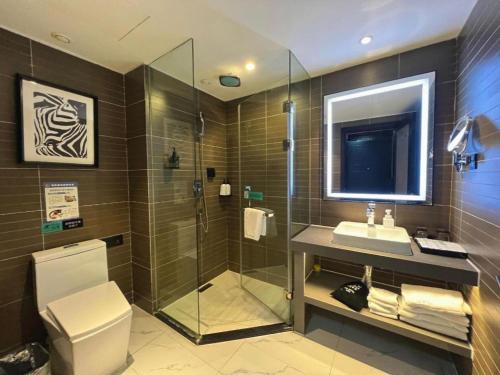 a bathroom with a shower and a sink and a toilet at Xana Hotelle Nanjing Xinjiekou Daxinggong Metro Station in Nanjing