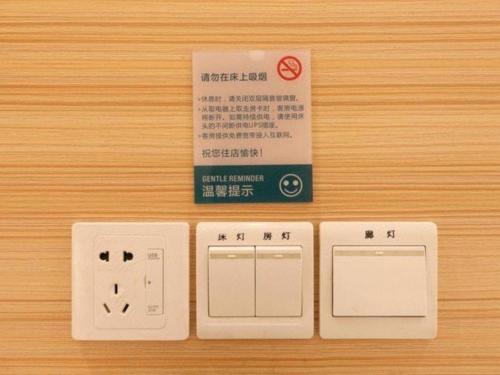 a set of three electrical switches on a wooden table at City Comfort Inn Wuhan Guanggu Textile University in Wuhan